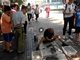 62岁无掌大爷街头画虎 一幅曾卖上万元